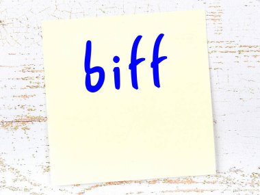 Biff 'i hatırlatma kavramı. Tahta duvarda üzerinde yazı olan sarı yapışkan kağıt.