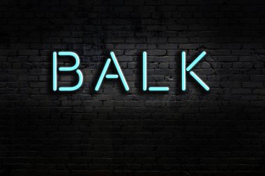 Üzerinde yazı olan neon levhası tuğla duvara karşı duruyor. Gece görünümü