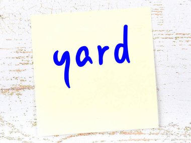 Avlu hakkında hatırlatma kavramı. Tahta duvarda üzerinde yazı olan sarı yapışkan kağıt.