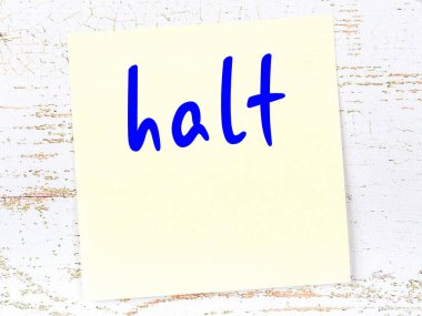 Tahta duvarda el yazısıyla yazılmış sarı nota dur