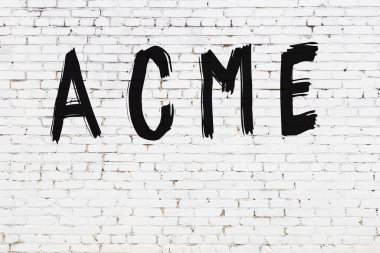 Beyaz tuğla duvara siyah boya ile yazılmış bir yazıt acme.