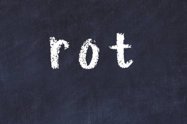 Tebeşir el yazısıyla yazılmış yazı siyah masada çürüyor.