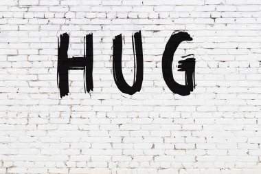 Yazı sarılması, beyaz duvara siyah boya ile yazılmış..