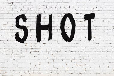 Yazılı beyaz tuğla duvar. Siyah boyayla yazılmış.