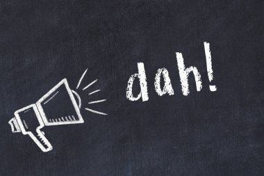 Hoparlörün tebeşir çizimi ve siyah masanın üzerine el yazısıyla yazılmış yazı dah