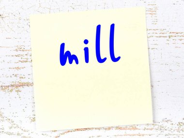 Değirmen hakkında hatırlatma kavramı. Tahta duvarda üzerinde yazı olan sarı yapışkan kağıt.