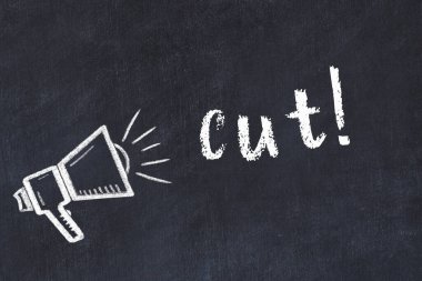 Hoparlörün tebeşir çizimi ve siyah masaya yazılmış el yazısı kesimi