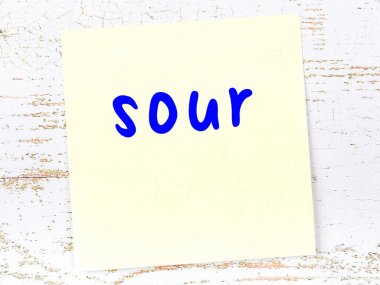 Tahta duvardaki sarı yapışkan notta el yazısı ekşi yazı var.