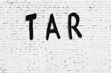 Üzerinde siyah boya olan beyaz tuğla duvar.