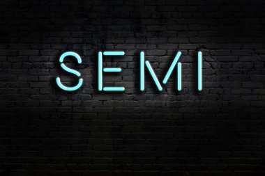 Duvara yazı kazınmış neon levhası. Gece görünümü