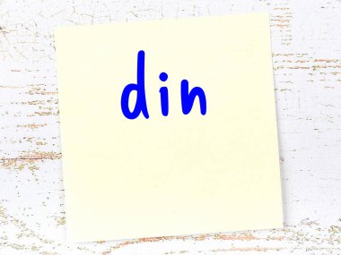 Din hakkında hatırlatma kavramı. Tahta duvarda üzerinde yazı olan sarı yapışkan kağıt.