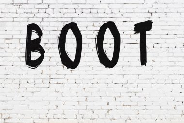 Beyaz tuğla duvara siyah boya ile yazılmış bir çizme..
