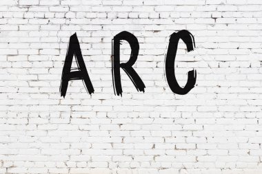 Yazılı beyaz tuğla duvar. Siyah boyalı el yazısı.