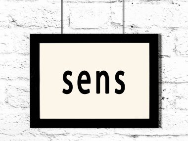 Siyah ahşap çerçeve, beyaz tuğla duvarda yazıt sensörleri asılı. 