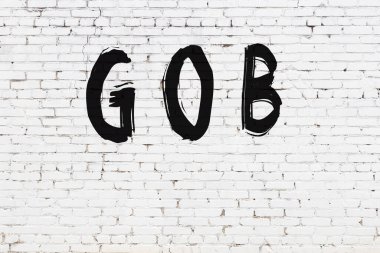 Üzerinde siyah boya bulunan beyaz tuğla bir duvar.