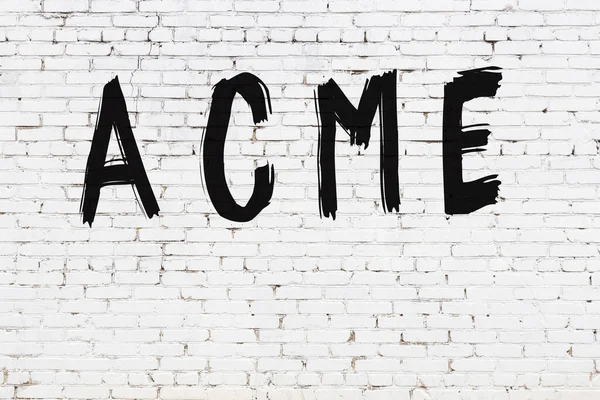 Beyaz tuğla duvara siyah boya ile yazılmış bir yazıt acme.