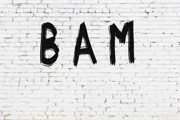 Yazılı beyaz tuğla duvar. Siyah boyalı el yazısı.