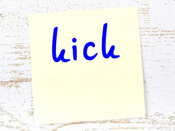 Tahta duvarda el yazısı tekmeli sarı yapışkan bir not.