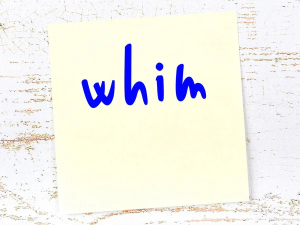 Hevesle ilgili bir hatırlatma. Tahta duvarda üzerinde yazı olan sarı yapışkan kağıt.