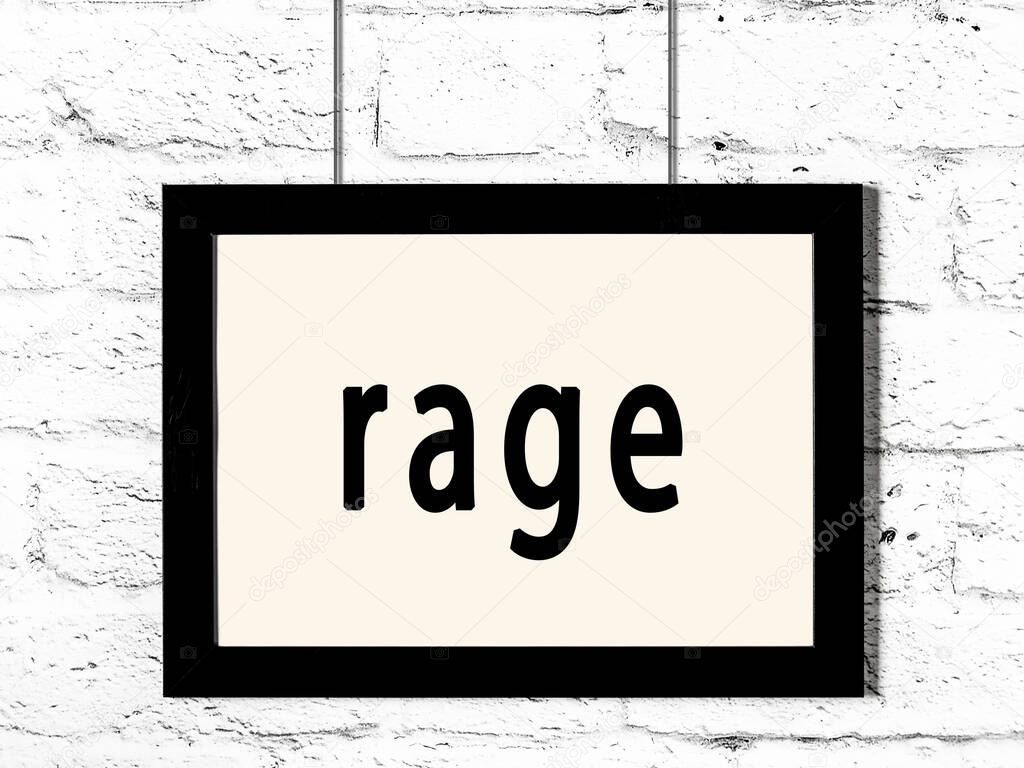 Black wooden frame with inscription rage hanging on white brick wall 