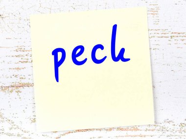 Tahta duvarda, el yazısıyla yazılmış gagalı sarı yapışkan bir not.