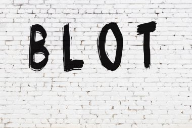 Üzerinde siyah boya bulunan beyaz tuğlalı duvar.