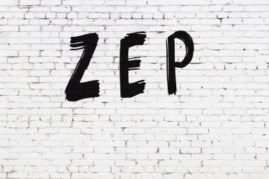 Beyaz tuğla duvarda siyah boyayla yazılmış yazılar..