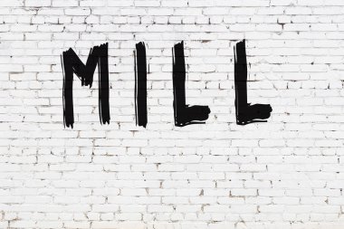 Siyah boyalı el yazısıyla yazması değirmen olan beyaz tuğla duvar.
