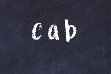 Tebeşir el yazısıyla yazılmış bir yazı taksisi siyah masada.