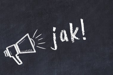 Hoparlörün tebeşir çizimi ve siyah masaya el yazısıyla yazılmış jak.