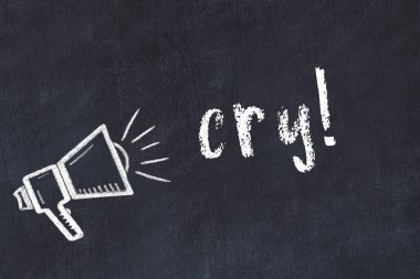 Hoparlörün tebeşir çizimi ve siyah masanın üzerine el yazısıyla yazılmış yazılar.