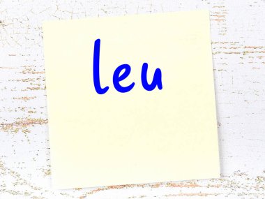 Tahta duvarda el yazısıyla yazılmış sarı yapışkan bir not var.