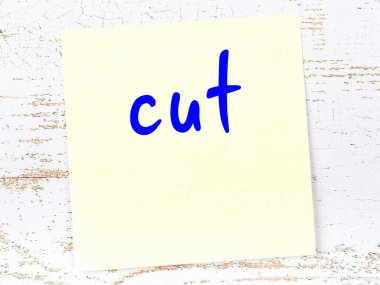 Tahta duvarda el yazısıyla kesilmiş sarı yapışkan bir not var.