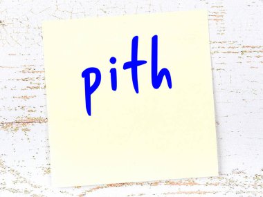 Tahta duvarda el yazısıyla yazılmış sarı yapışkan bir not var.