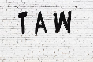 Yazılı beyaz tuğla duvar. Siyah boyalı el yazısı.