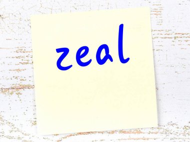 Tahta duvarda el yazısıyla yazılmış sarı yapışkan bir not.