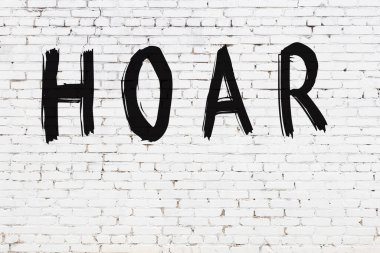 Beyaz tuğla duvarda siyah boyayla yazılmış bir çukur..