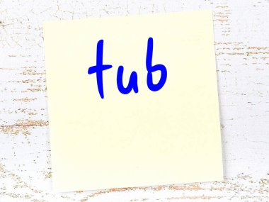 Küvet hakkında hatırlatma kavramı. Tahta duvarda üzerinde yazı olan sarı yapışkan kağıt.