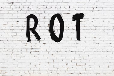 Üzerinde yazı olan beyaz tuğla duvar, el yazısıyla siyah boya ile çürümüş.