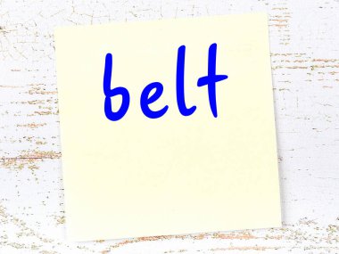 Tahta duvardaki sarı yapışkan notta el yazısı kemer var.