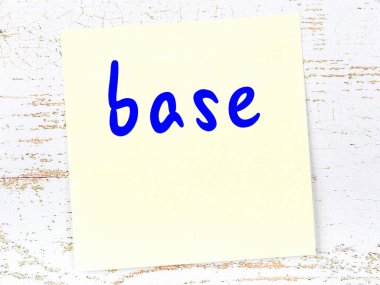 Tahta duvarda el yazısıyla yazılmış sarı yapışkan bir not var.