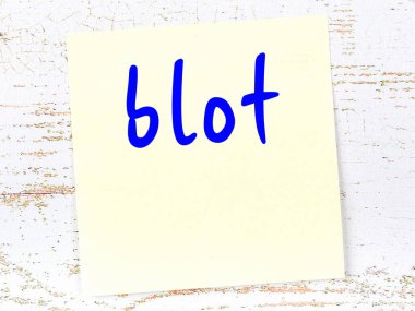 Tahta duvarda el yazısı lekeli sarı yapışkan bir not.