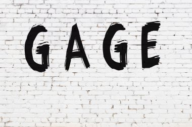 Beyaz tuğla duvara siyah boya ile yazılmış bir karton..