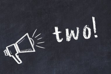 Hoparlörün tebeşir çizimi ve siyah masaya el yazısıyla yazılmış ikinci yazı.