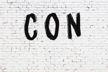 Beyaz tuğla duvara siyah boya ile yazılmış bir yazı..