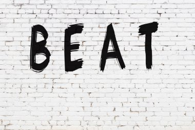 Yazılı beyaz tuğla duvar siyah boyayla yazılmış.