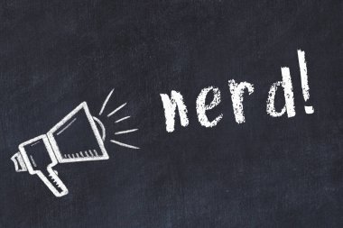 Hoparlörün tebeşir çizimi ve siyah masanın üzerine el yazısıyla yazılmış inek.