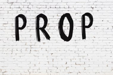 Beyaz tuğla duvara siyah boya ile yazılmış bir yazı..