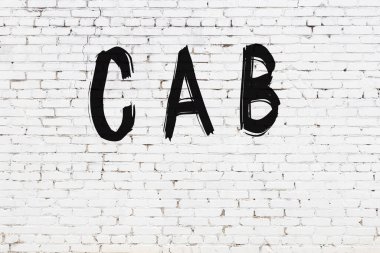 Üzerinde siyah boya olan beyaz tuğlalı bir duvar.