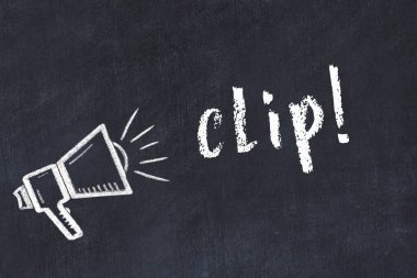 Hoparlörün tebeşir çizimi ve siyah masanın üzerine el yazısıyla yazılmış yazması.